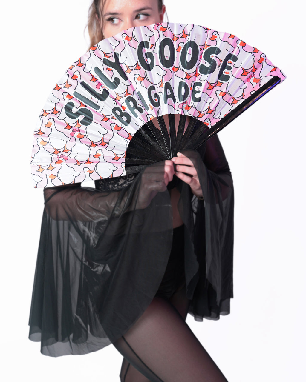 Person holding a fan with 'Silly Goose Brigade' text and cartoon ducks design.