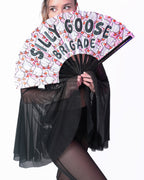 Person holding a fan with 'Silly Goose Brigade' text and cartoon ducks design.