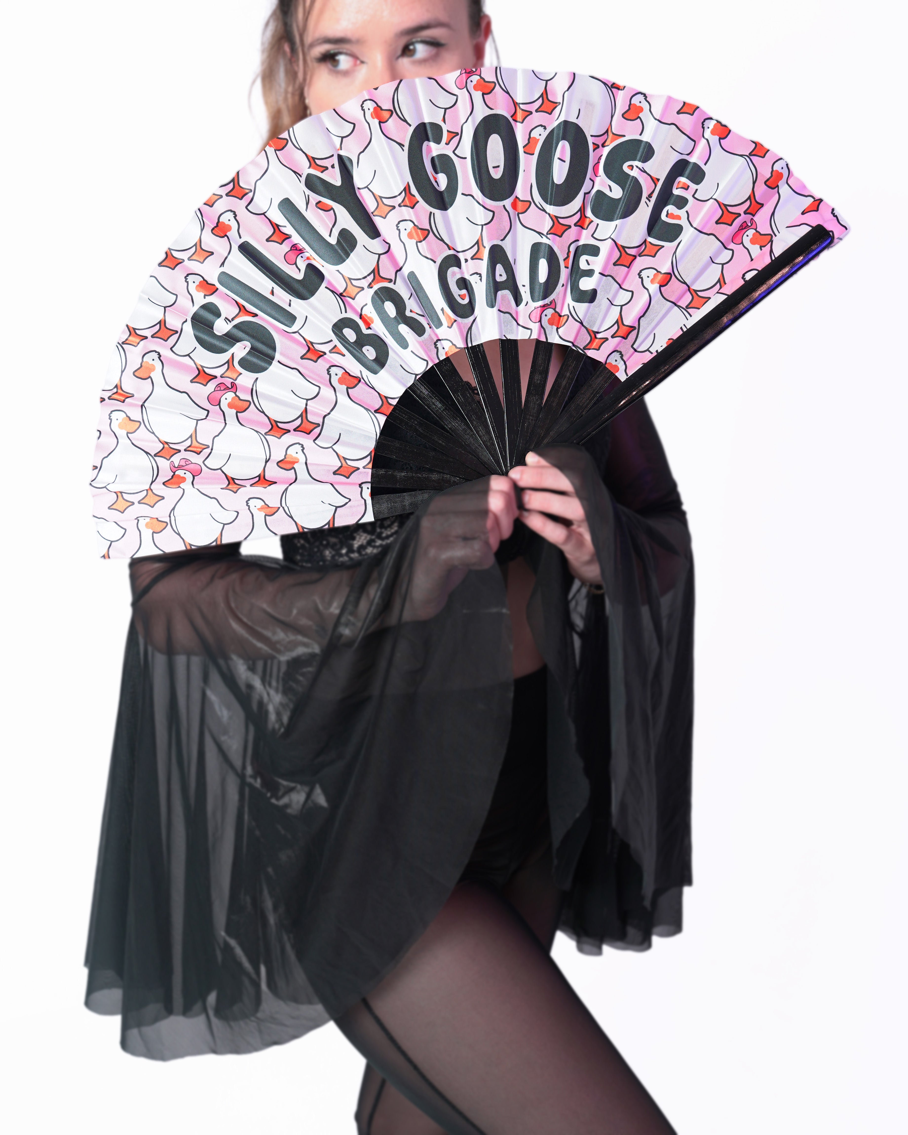 Person holding a fan with 'Silly Goose Brigade' text and cartoon ducks design.