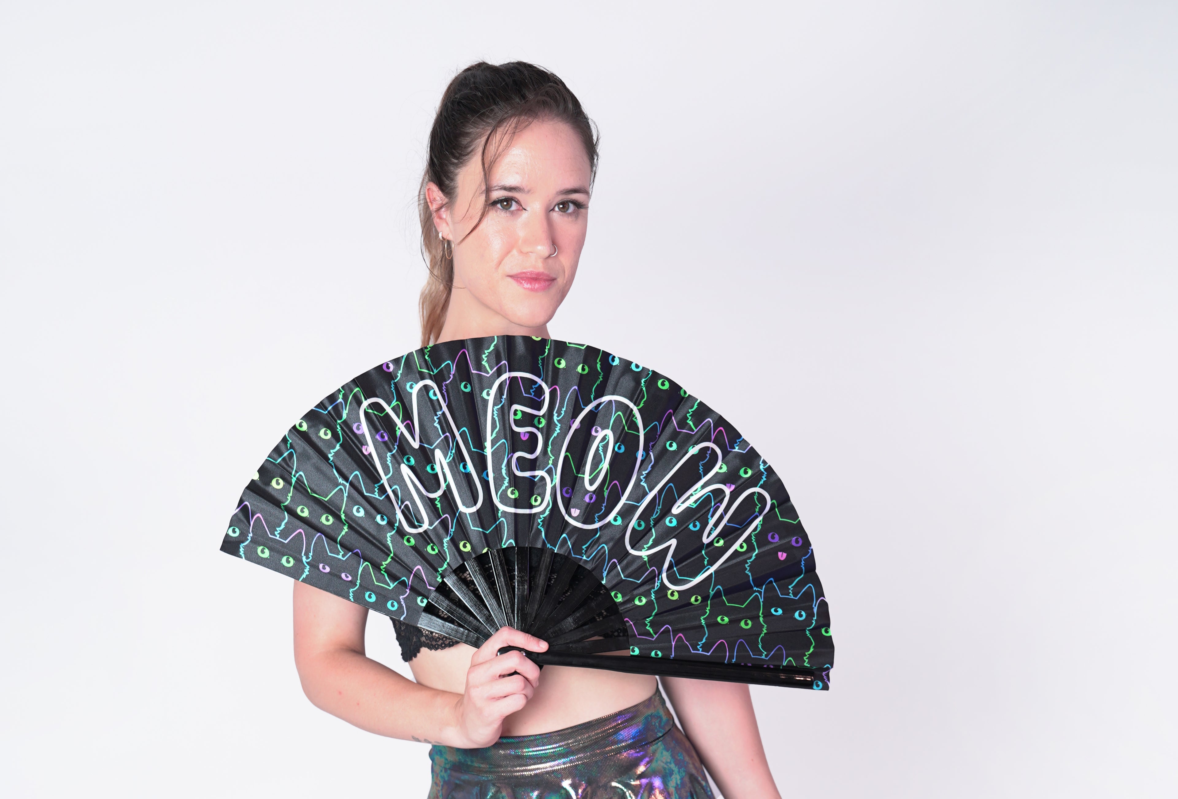 Person holding a black fan with 'MEOW' in white letters over neon outlines of cats